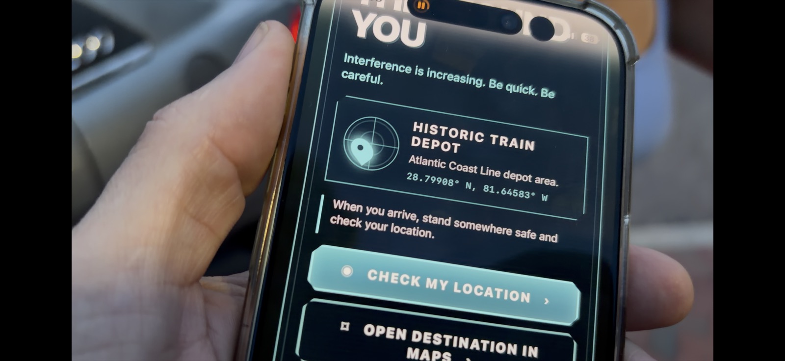 A field tester using a phone to find the next Story Ark location